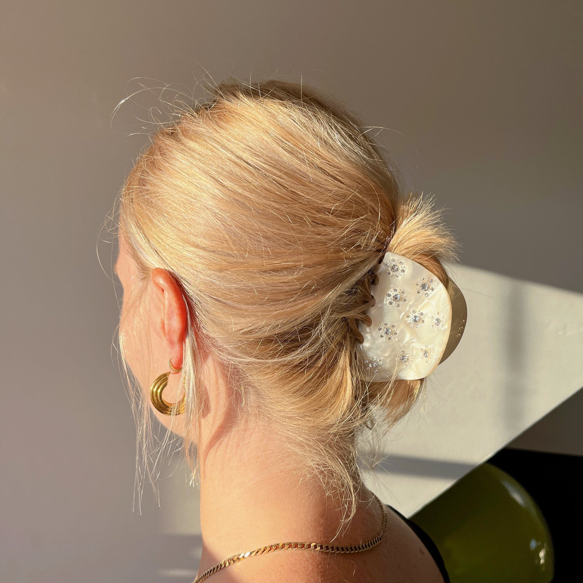 Meet RANA!  A medium to large silhouette claw in a half moon shape with rhinestone accents. The solid shape and close teeth, create a strong grip, making it great for fine hair and thick hair.  Each clip comes in a branded Tort pouch (colours change seasonally).  Size: 7.5cm  Colour: ivory pearl with crystal jewels and silver studs  Material: eco-resin