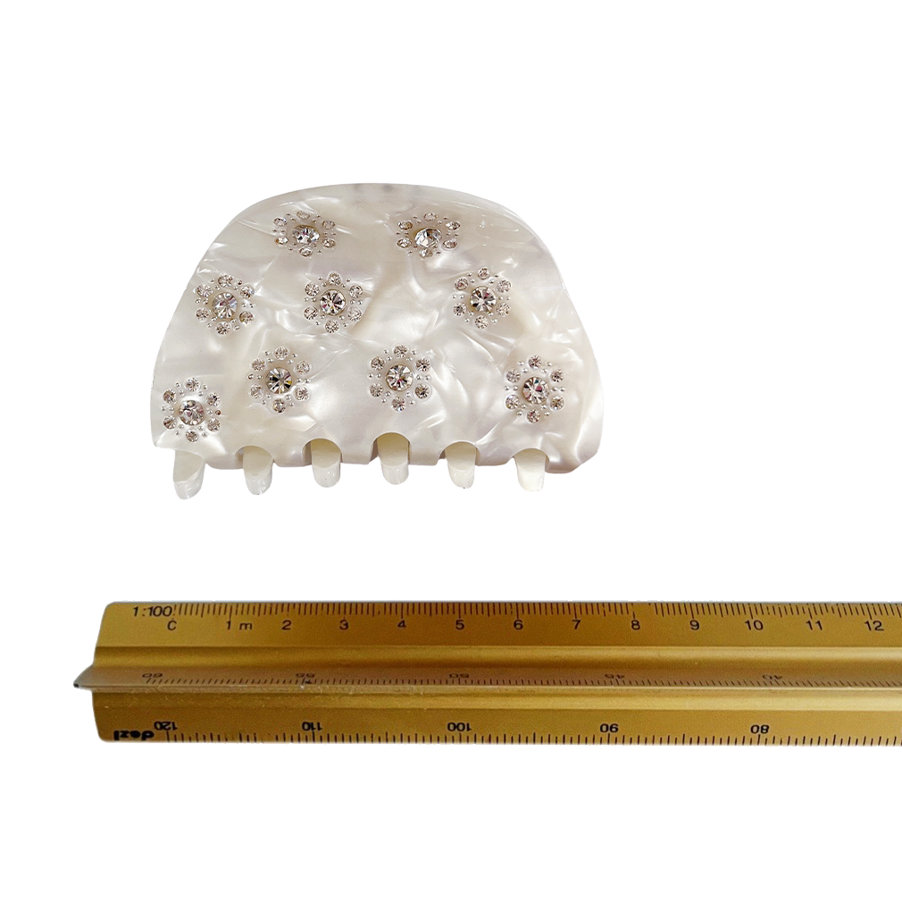Meet RANA!  A medium to large silhouette claw in a half moon shape with rhinestone accents. The solid shape and close teeth, create a strong grip, making it great for fine hair and thick hair.  Each clip comes in a branded Tort pouch (colours change seasonally).  Size: 7.5cm  Colour: ivory pearl with crystal jewels and silver studs  Material: eco-resin