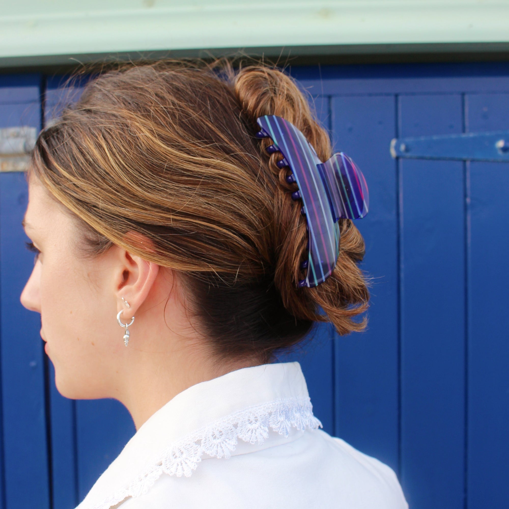 Meet ANNA!  A curved classic shape hair claw with double grip finish. The curved design makes it perfect for that all up look, and with the teeth being close together the grip works to hold all hair, from fine to thick.  Each clip comes in a branded Tort pouch (colours change seasonally).  Size: 12cm  Colour: navy blue with electric multi-colour stripes  Material: eco-resin