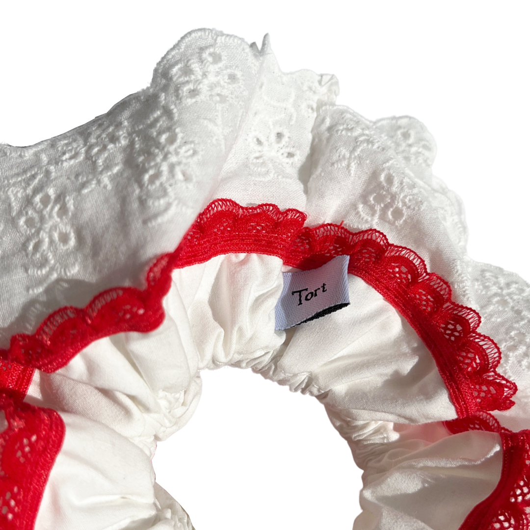 Meet GILA!  A scrunchie big enough to hold all hair. Four layers of broderie anglaise and cotton centre make it perfect for an all up look or for securing a bun on thicker hair. Try it tied twice round on finer hair.  Each scrunchie comes with a pink ribbon tag on which can be used as a gift tag.  Size: approx 18cm  Colour: White lace with a cherry red lace accent  Material: Cotton