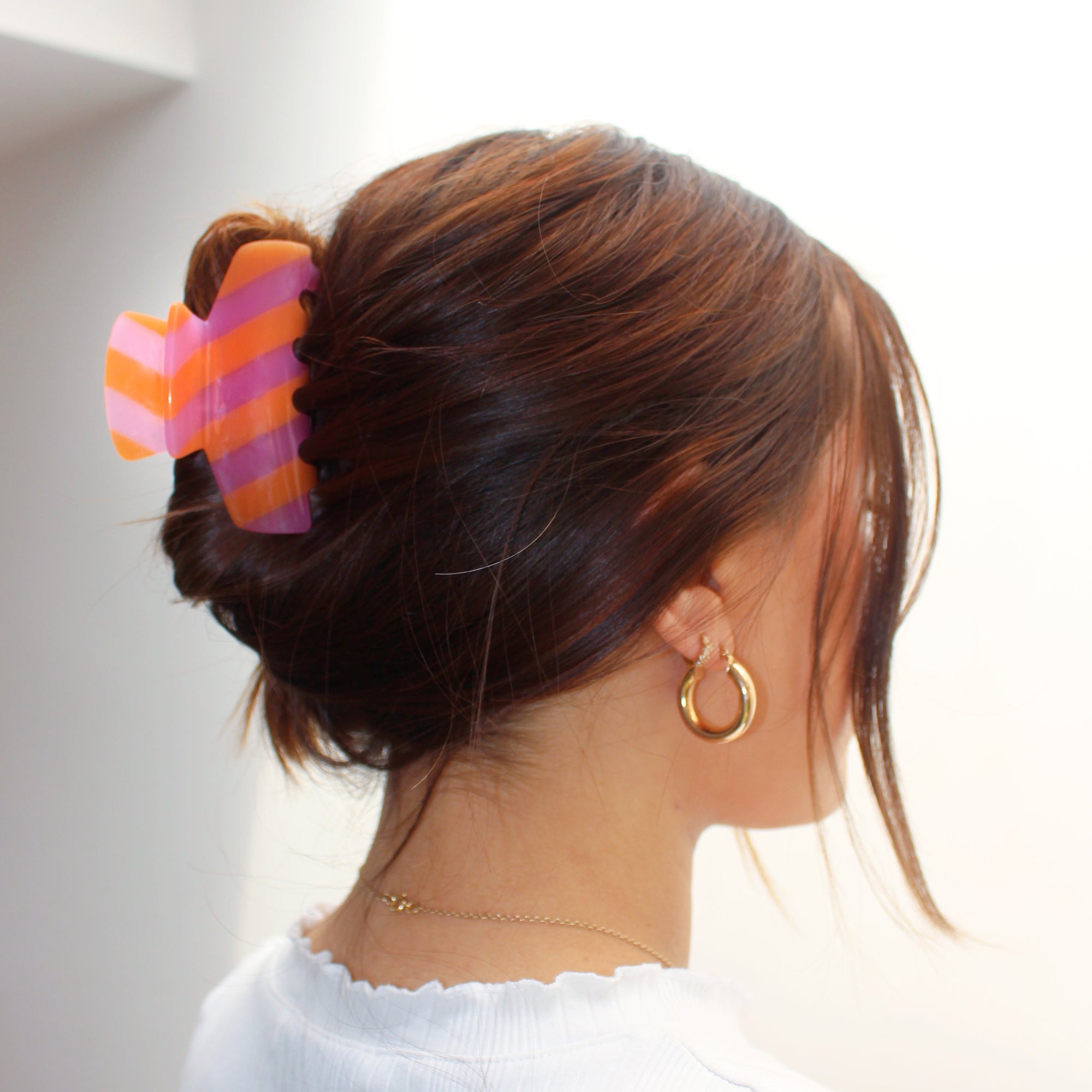 Meet LORA!  A medium sized silhouette claw in our signature stripes. Two resin patterns are merged together to create a colour combinations of dreams. The medium size makes it very easy to use and perfect for an all up look or securing a bun. For shorter hair it can be used for an all up look.  Each clip comes in a branded Tort pouch (colours change seasonally).  Size: 9cm  Colour: hot pink and orange stripe  Material: eco-resin