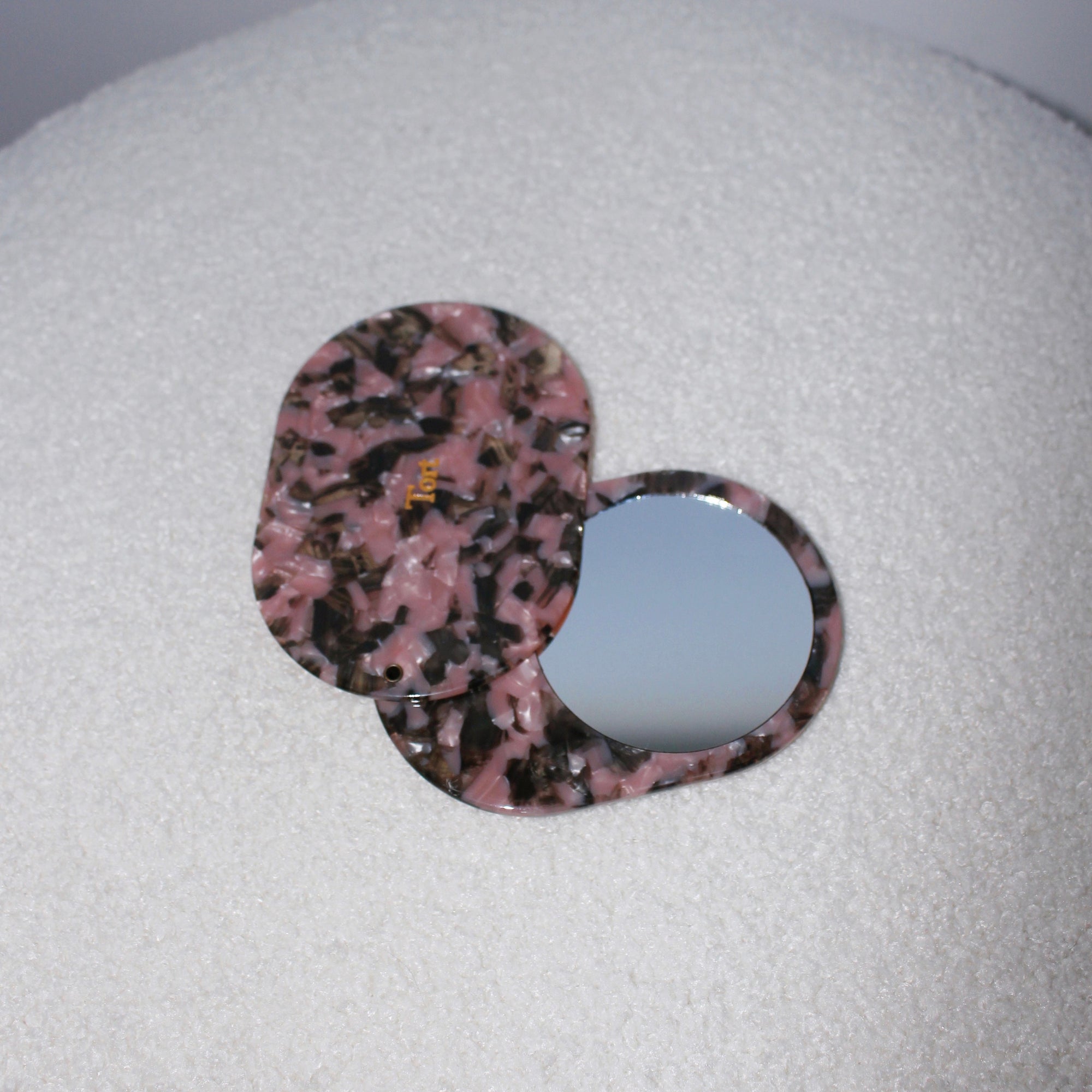 Meet JAYA!  A compact mirror is a handbag essential. Made from smooth, hand-poured eco-resin, the JAYA mirror is super cute with added protection and cleanliness through a sliding mechanism.  Each mirror comes in a branded Tort pouch (colours change seasonally).  Size: 10.5cm  Colour: marbled blush pink and chocolate brown  Material: eco-resin