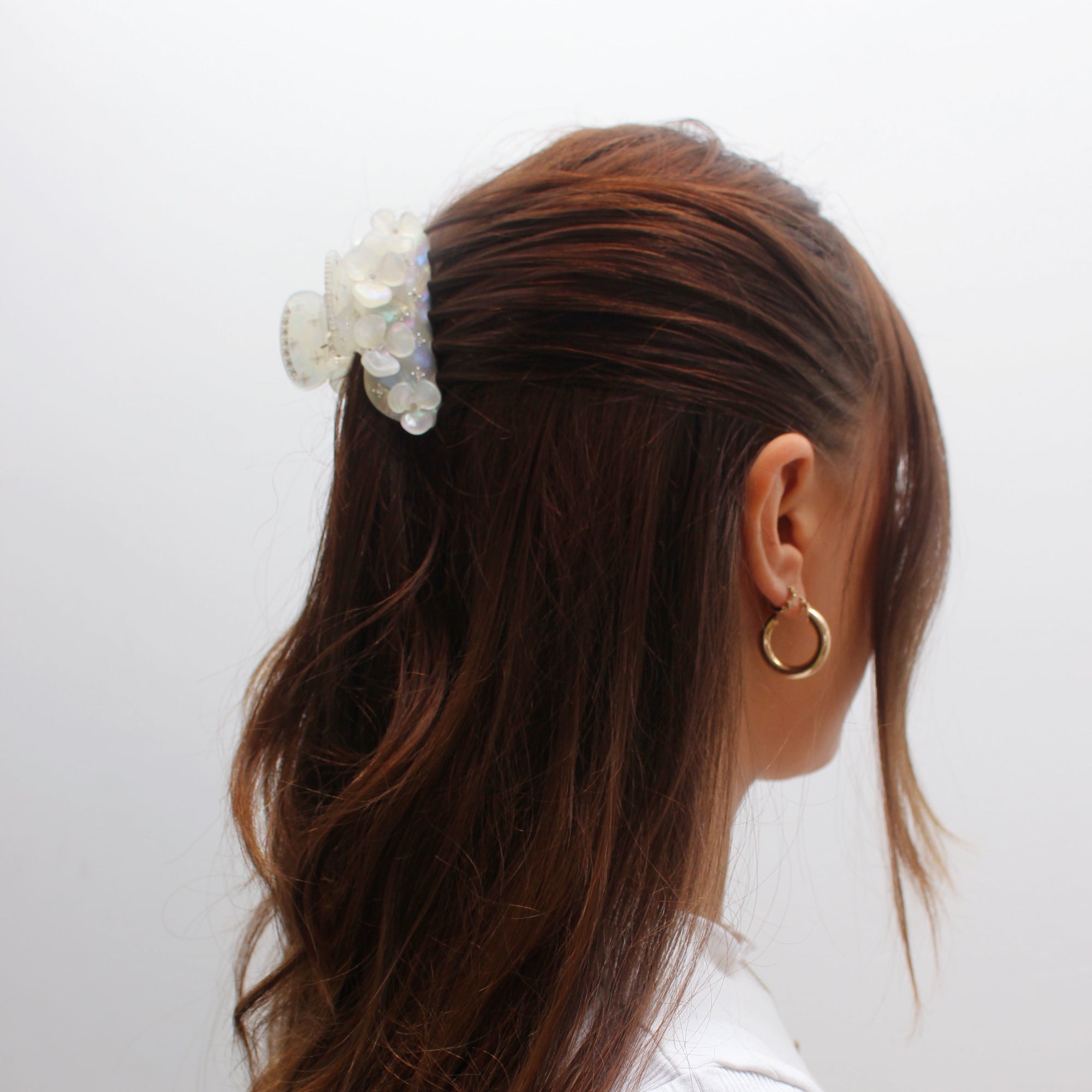 Meet JOAN!  A medium sized silhouette claw with flower and rhinestone details. The medium size makes it very easy to use and perfect for an all up look or securing a bun. For shorter hair it can be used for an all up look. It looks as cute off as on the hair.  Each clip comes in a branded Tort pouch (colours change seasonally).  Size: 7.5cm  Colour: pearlescent white with iridescent daisies and crystal rhinestone accents  Material: eco-resin