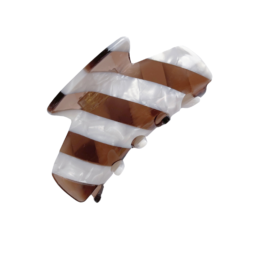 Meet LORA!  A medium sized silhouette claw in our signature stripes. Two resin patterns are merged together to create a colour combinations of dreams. The medium size makes it very easy to use and perfect for an all up look or securing a bun. For shorter hair it can be used for an all up look.  Each clip comes in a branded Tort pouch (colours change seasonally).  Size: 9cm  Colour: translucent chocolate brown and marbled white stripe  Material: eco-resin
