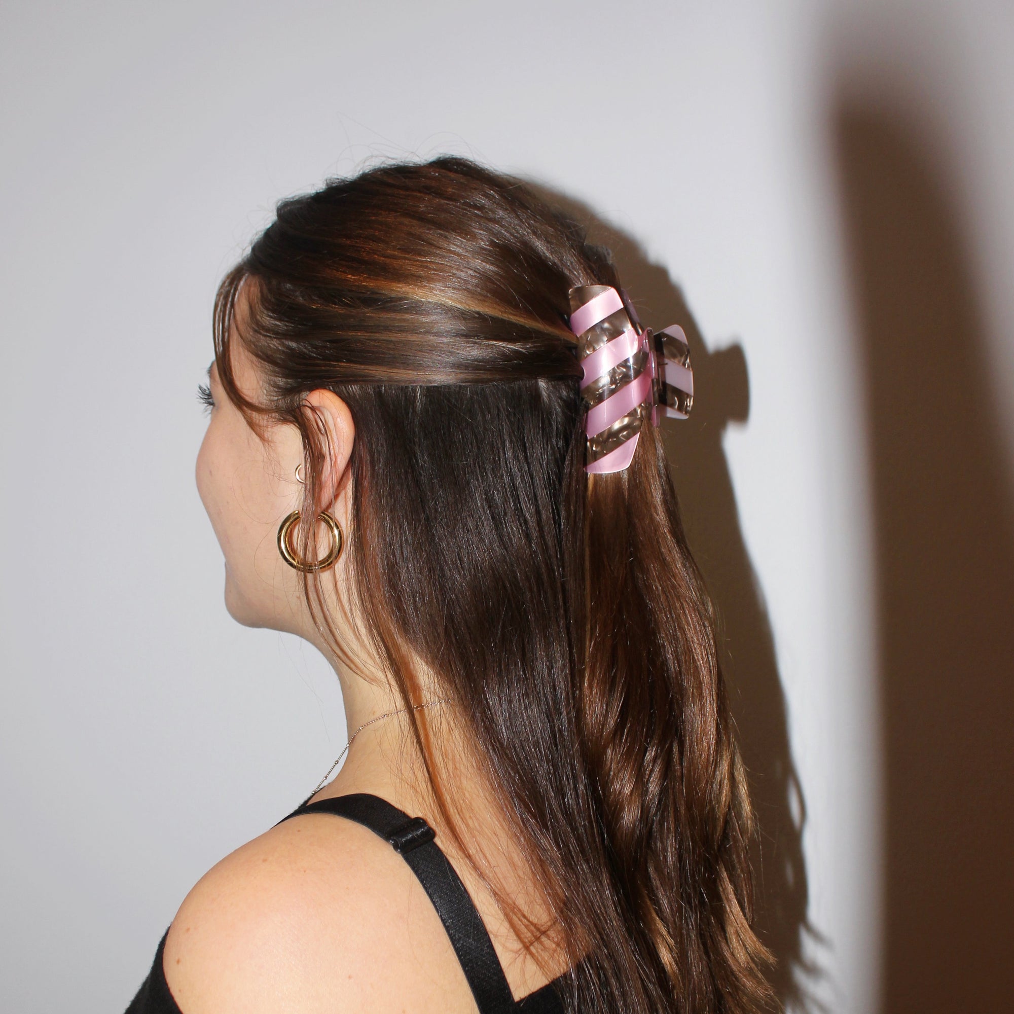 Meet LORA!  A medium sized silhouette claw in our signature stripes. Two resin patterns are merged together to create a colour combinations of dreams. The medium size makes it very easy to use and perfect for an all up look or securing a bun. For shorter hair it can be used for an all up look.  Each clip comes in a branded Tort pouch (colours change seasonally).  Size: 9cm  Colour: metallic pink and marbled chocolate brown stripe  Material: eco-resin 