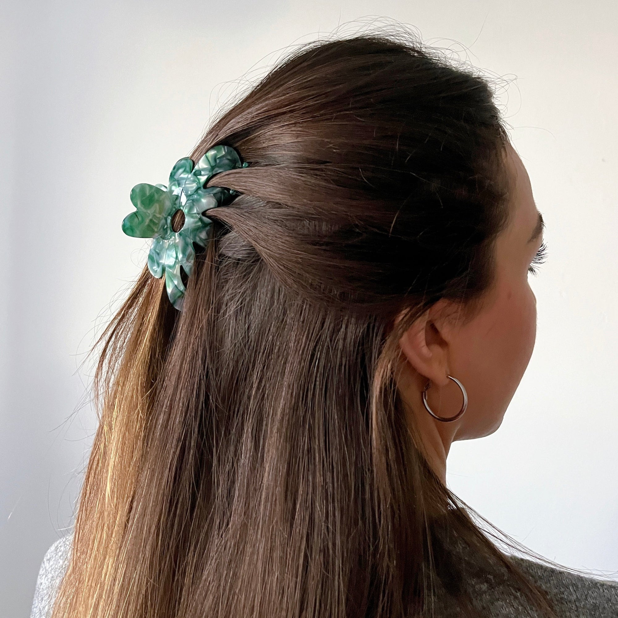 Meet AMMA!  A floral shaped medium size claw. The medium size makes it very easy to use. For medium thickness/length it can be used for an all up look and for finer and thick hair, it will probably be best styled securing a bun or a half up style.  Each clip comes in a branded Tort pouch (colours change seasonally).  Size: 9.5cm  Colour: marbled iridescent teal green  Material: eco-resin