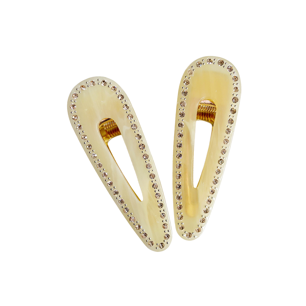 Meet CORA!  Our OG clip, a rounded-edge barrette featuring rhinestones and gold hinge fastening with a teeth effect grip for a sturdy and reliable hold. Great for keeping hair in place or simply clipping back your grown out fringe.  Each clip comes in a branded Tort pouch (colours change seasonally).  Size: 7cm  Colour: pale yellow with yellow rhinestone accents  Material: eco-resin