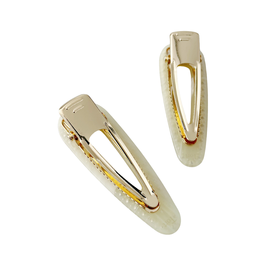 Meet CORA!  Our OG clip, a rounded-edge barrette featuring rhinestones and gold hinge fastening with a teeth effect grip for a sturdy and reliable hold. Great for keeping hair in place or simply clipping back your grown out fringe.  Each clip comes in a branded Tort pouch (colours change seasonally).  Size: 7cm  Colour: pale yellow with yellow rhinestone accents  Material: eco-resin