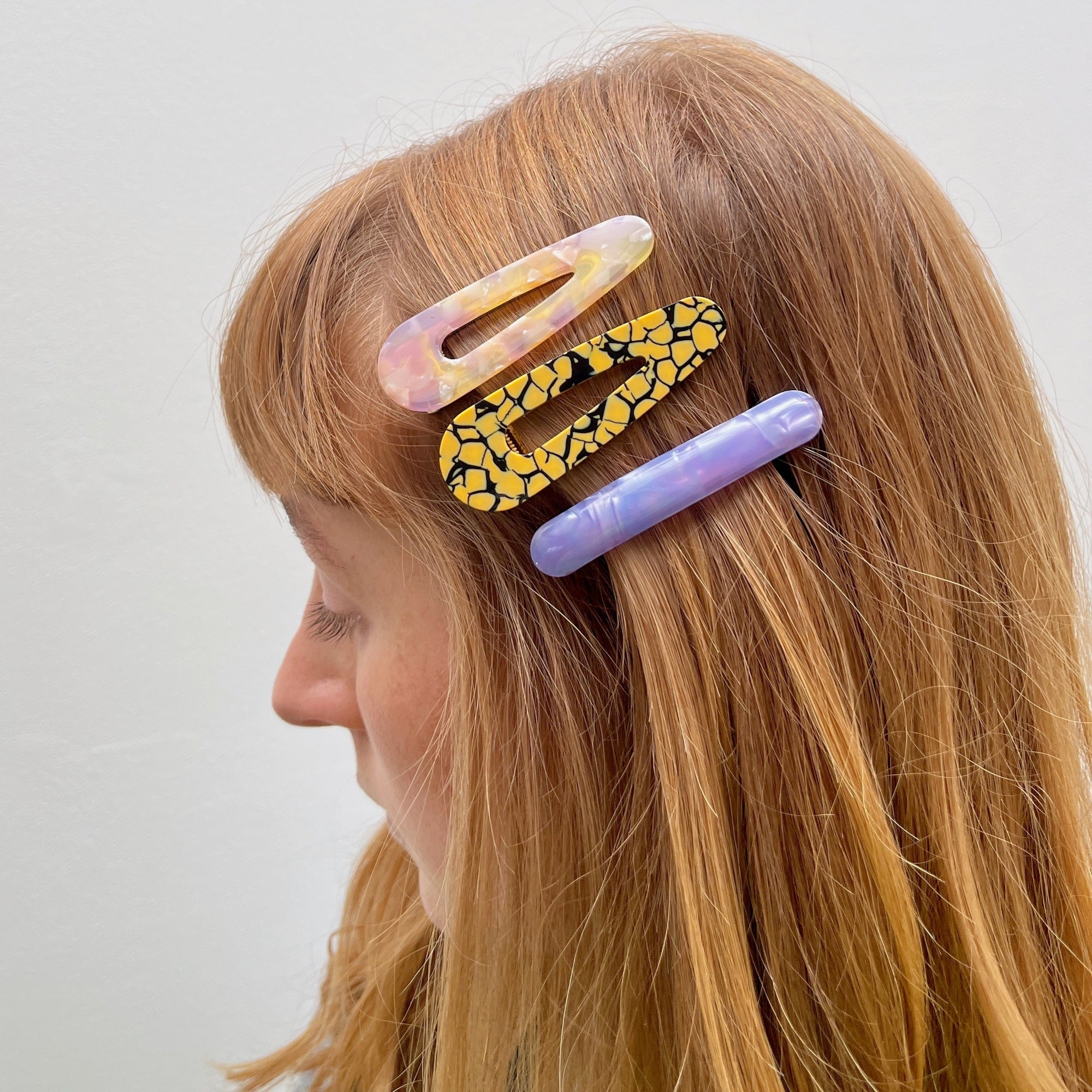 Meet CORA!  Our OG clip, a rounded-edge barrette featuring a gold hinge fastening and a teeth effect grip for a sturdy and reliable hold. Great for keeping hair in place or simply clipping back your grown out fringe.  Each clip comes in a branded Tort pouch (colours change seasonally).  Size: 7cm  Colour: yellow and black mosaic effect  Material: eco-resin
