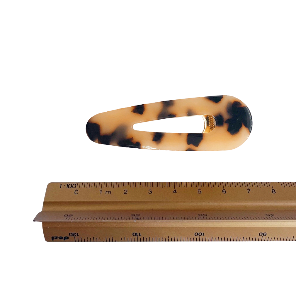 Meet CORA!  Our OG clip, a rounded-edge barrette featuring a gold hinge fastening and a teeth effect grip for a sturdy and reliable hold. Great for keeping hair in place or simply clipping back your grown out fringe.  Each clip comes in a branded Tort pouch (colours change seasonally).  Size: 7cm  Colour: warm tortoiseshell  Material: eco-resin