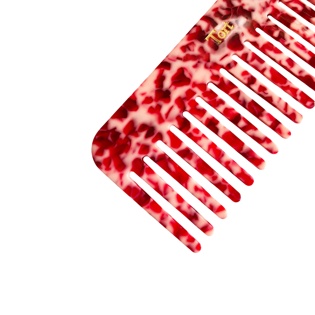 Meet ELVA!  A sturdy round-edged rectangle comb made from eco-resin. Designed with medium positioned rounded teeth so that hair retains texture and strength. Glides through wet or dry hair to untangle or tease after curling with tongs or straighteners, while preventing breakage, split ends and frizz.   Each comb comes in a branded Tort pouch (colours change seasonally).  Size: 15cm  Colour: marbled ruby red  Material: eco-resin   Combs are non-refundable for hygiene reasons.