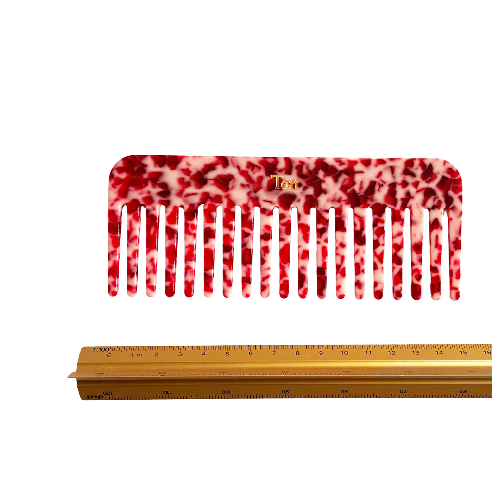 Meet ELVA!  A sturdy round-edged rectangle comb made from eco-resin. Designed with medium positioned rounded teeth so that hair retains texture and strength. Glides through wet or dry hair to untangle or tease after curling with tongs or straighteners, while preventing breakage, split ends and frizz.   Each comb comes in a branded Tort pouch (colours change seasonally).  Size: 15cm  Colour: marbled ruby red  Material: eco-resin   Combs are non-refundable for hygiene reasons.