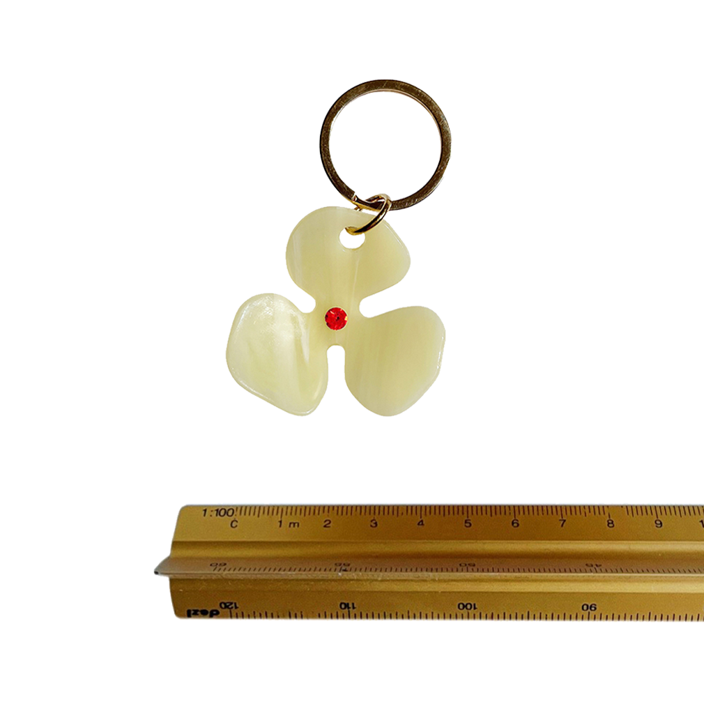 Meet FLOR!  A bleached lemon yellow flower with an orange jewel in the centre and Tort logo embossed on the back. Complete with brass-gold keyring hardware so you're able to attach to keys.  Each keyring comes in a branded Tort pouch (colours change seasonally).  Size: 4.5cm  Colour: bleached lemon yellow with orange jewel  Material: eco-resin