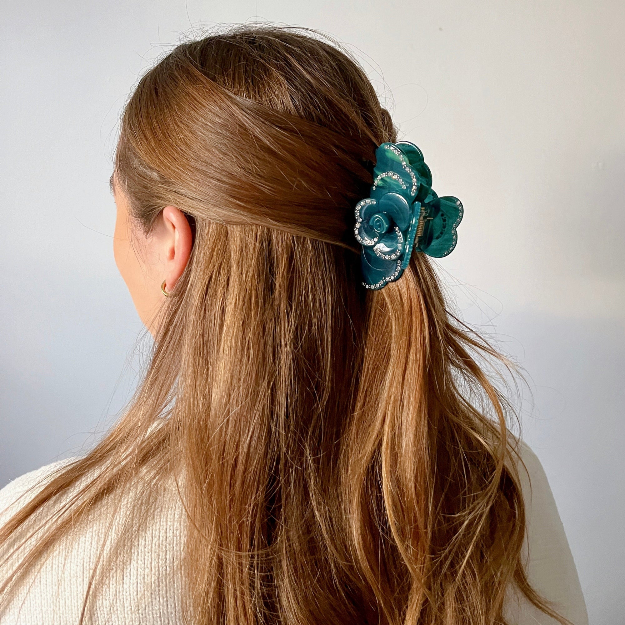 Meet SUZY!  A medium-large clip with flower-shaped detail and rhinestone detailing on each side. Best for half up-half-down looks on thicker hair, while it’s great styled, any-way on medium to fine hair.  Each clip comes in a branded Tort pouch (colours change seasonally).  Size: 9cm  Colour: petrol-blue and aqua with rhinestone accents and silver studs  Material: eco-resin 